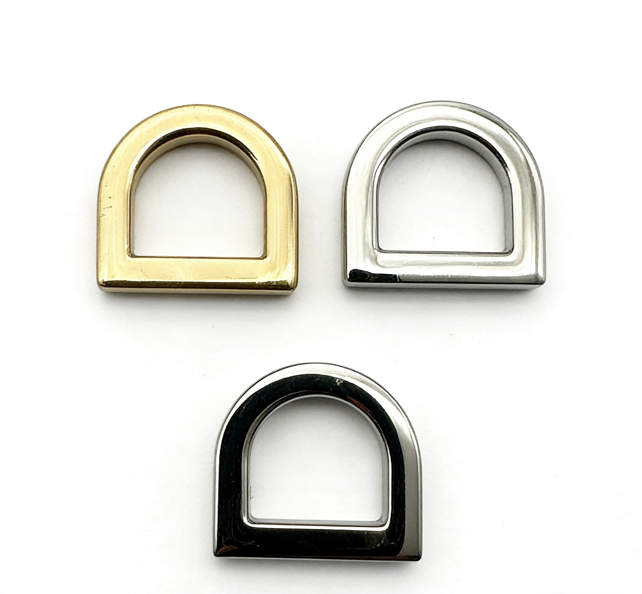 High-end chunky solid D-rings in light gold, mirror silver, and glossy gunmetal finishes for heavy-duty luxury bags, custom OEM manufactured by Wahkoi Metal.