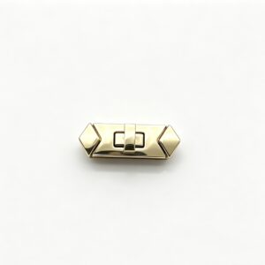 Close-up of a high-polish light gold rectangular twist lock featuring geometric diamond ends for luxury handbags, custom manufactured by Wahkoi Metal