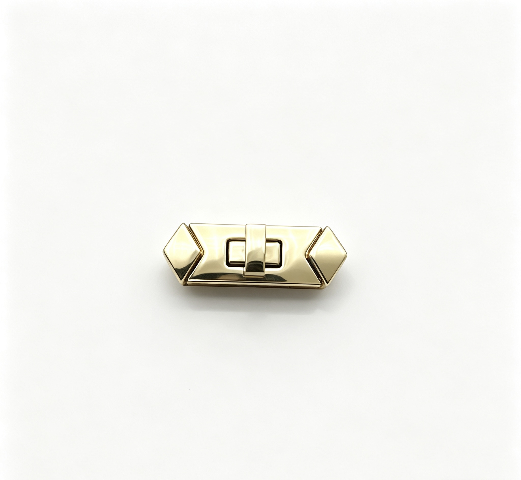 Close-up of a high-polish light gold rectangular twist lock featuring geometric diamond ends for luxury handbags, custom manufactured by Wahkoi Metal