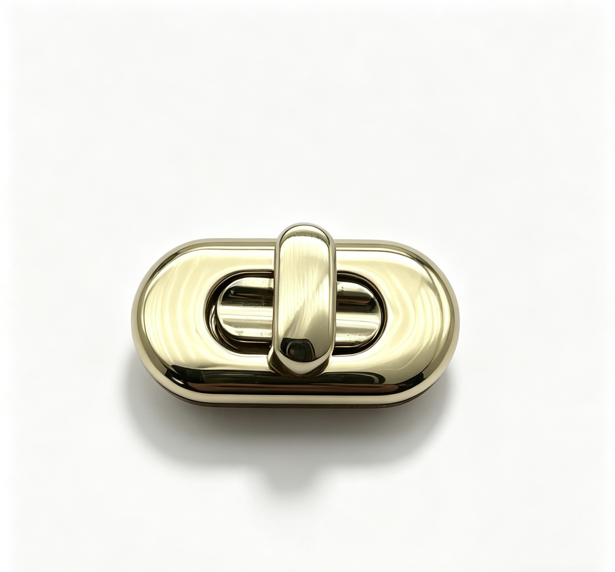 Close-up of a high-polish light gold elongated oval twist lock with seamless contours for luxury handbags, custom manufactured by Wahkoi Metal