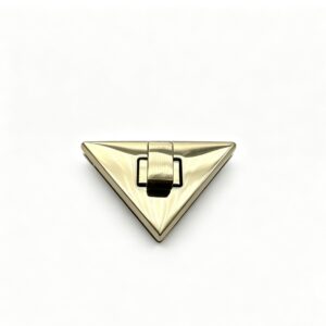 Close-up of a high-polish light gold geometric triangle twist lock for luxury envelope handbags, custom manufactured by Wahkoi Metal