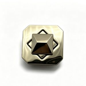 Close-up of a high-polish light gold octagonal twist lock featuring a 3D pyramid stud turn mechanism for luxury handbags, custom manufactured by Wahkoi Metal