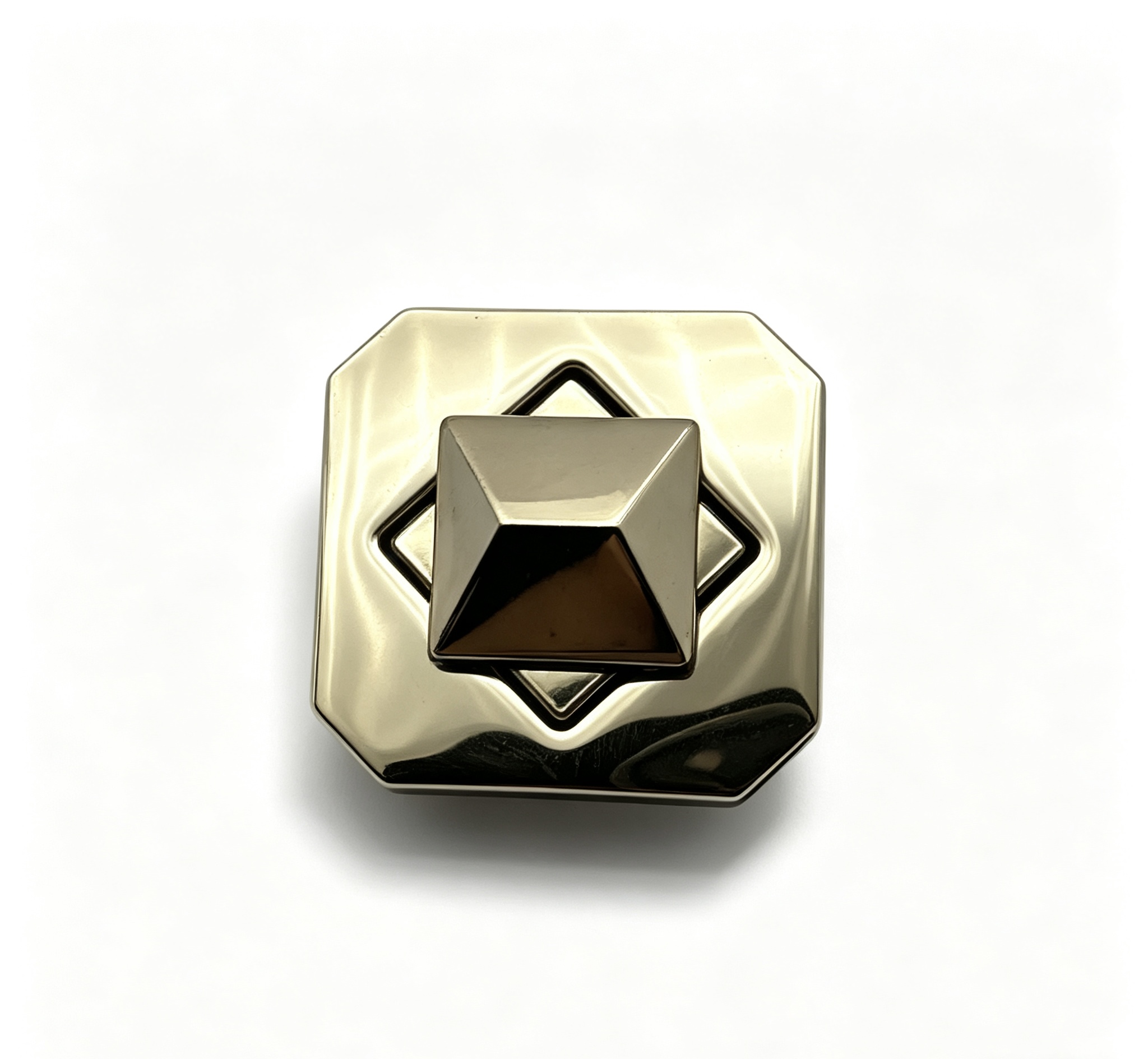 Close-up of a high-polish light gold octagonal twist lock featuring a 3D pyramid stud turn mechanism for luxury handbags, custom manufactured by Wahkoi Metal
