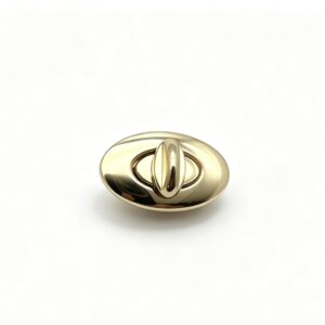 Close-up of a high-polish light gold oval twist lock hardware for luxury handbags manufactured by Wahkoi Metal