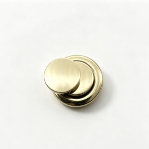 Close-up of a high-polish light gold overlapping double circle bag lock hardware for luxury handbags, custom manufactured by Wahkoi Metal