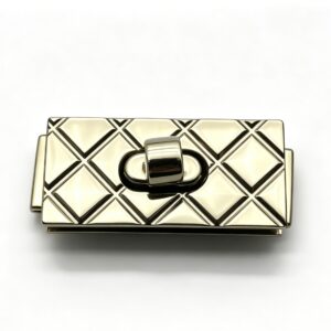 Close-up of a high-polish light gold rectangular twist lock featuring a classic quilted diamond pattern for luxury handbags, custom manufactured by Wahkoi Metal