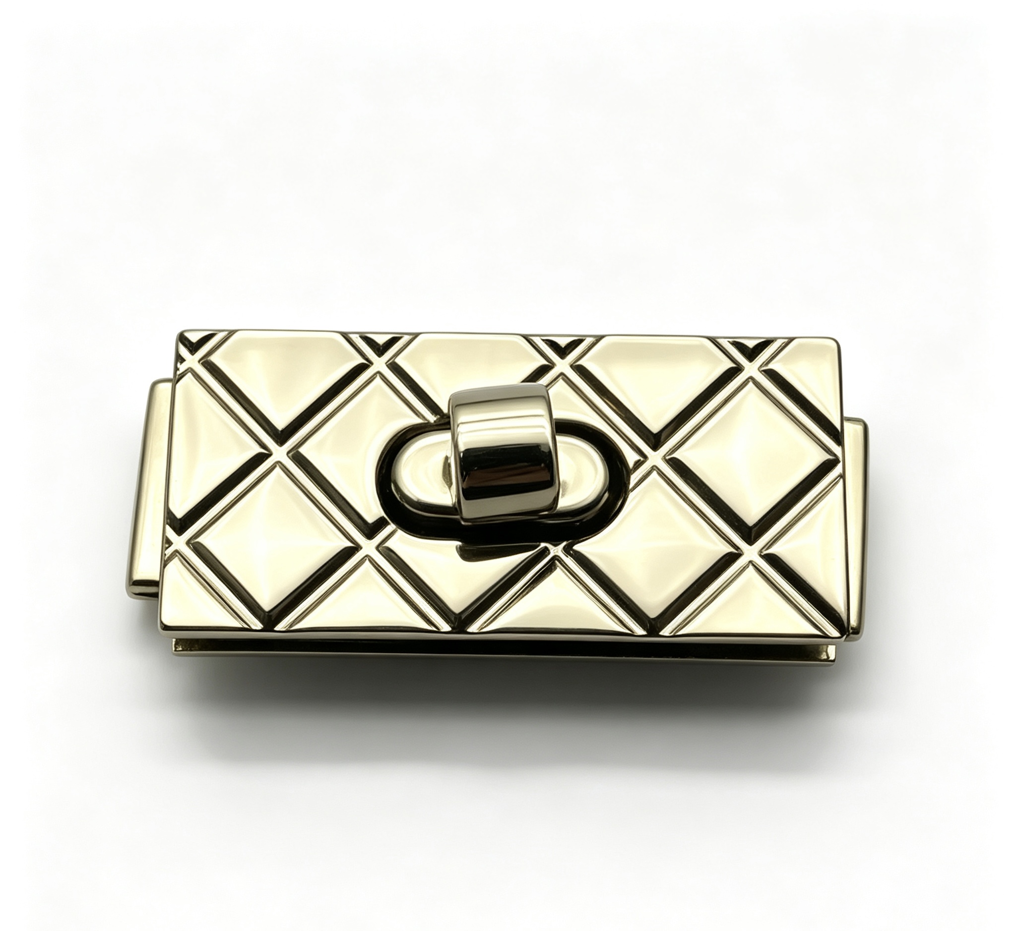 Close-up of a high-polish light gold rectangular twist lock featuring a classic quilted diamond pattern for luxury handbags, custom manufactured by Wahkoi Metal