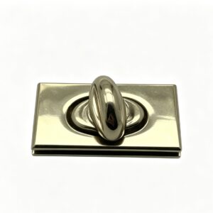Close-up of a high-polish light gold rectangular twist lock featuring a recessed oval center for luxury handbags, custom manufactured by Wahkoi Metal