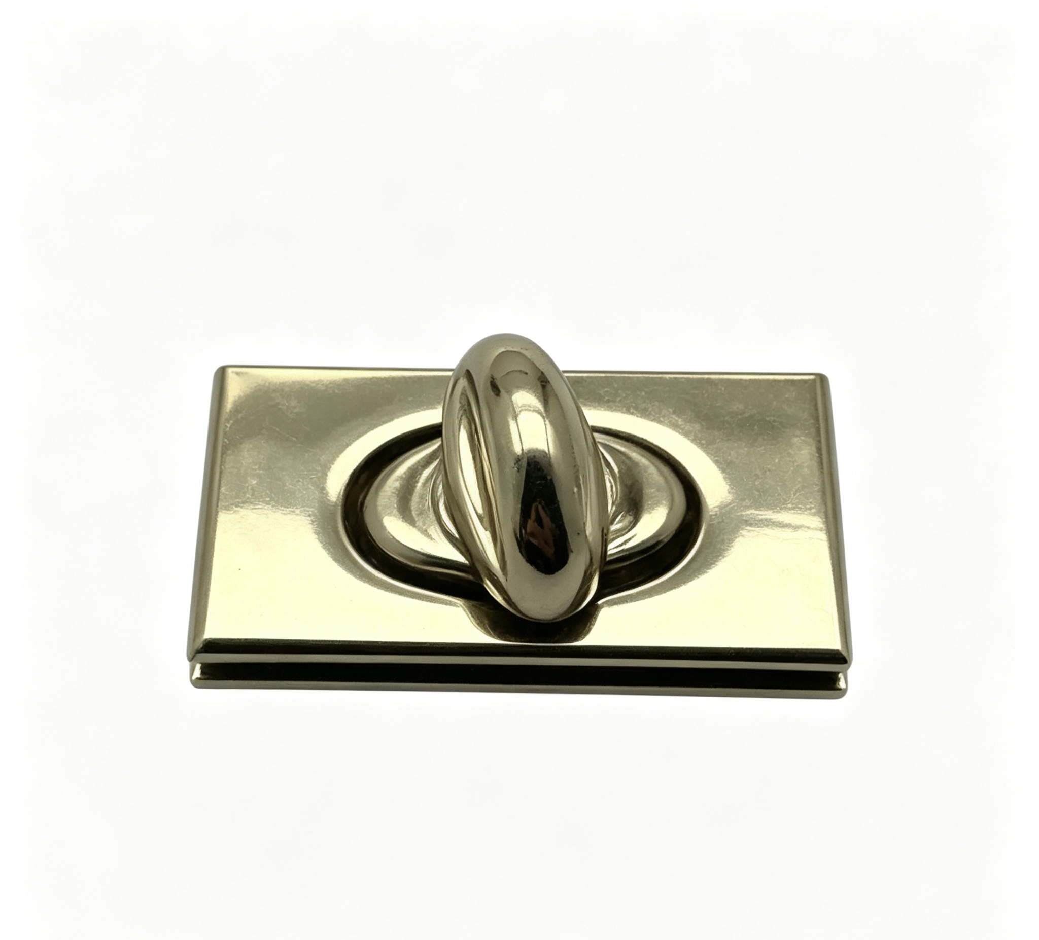 Close-up of a high-polish light gold rectangular twist lock featuring a recessed oval center for luxury handbags, custom manufactured by Wahkoi Metal