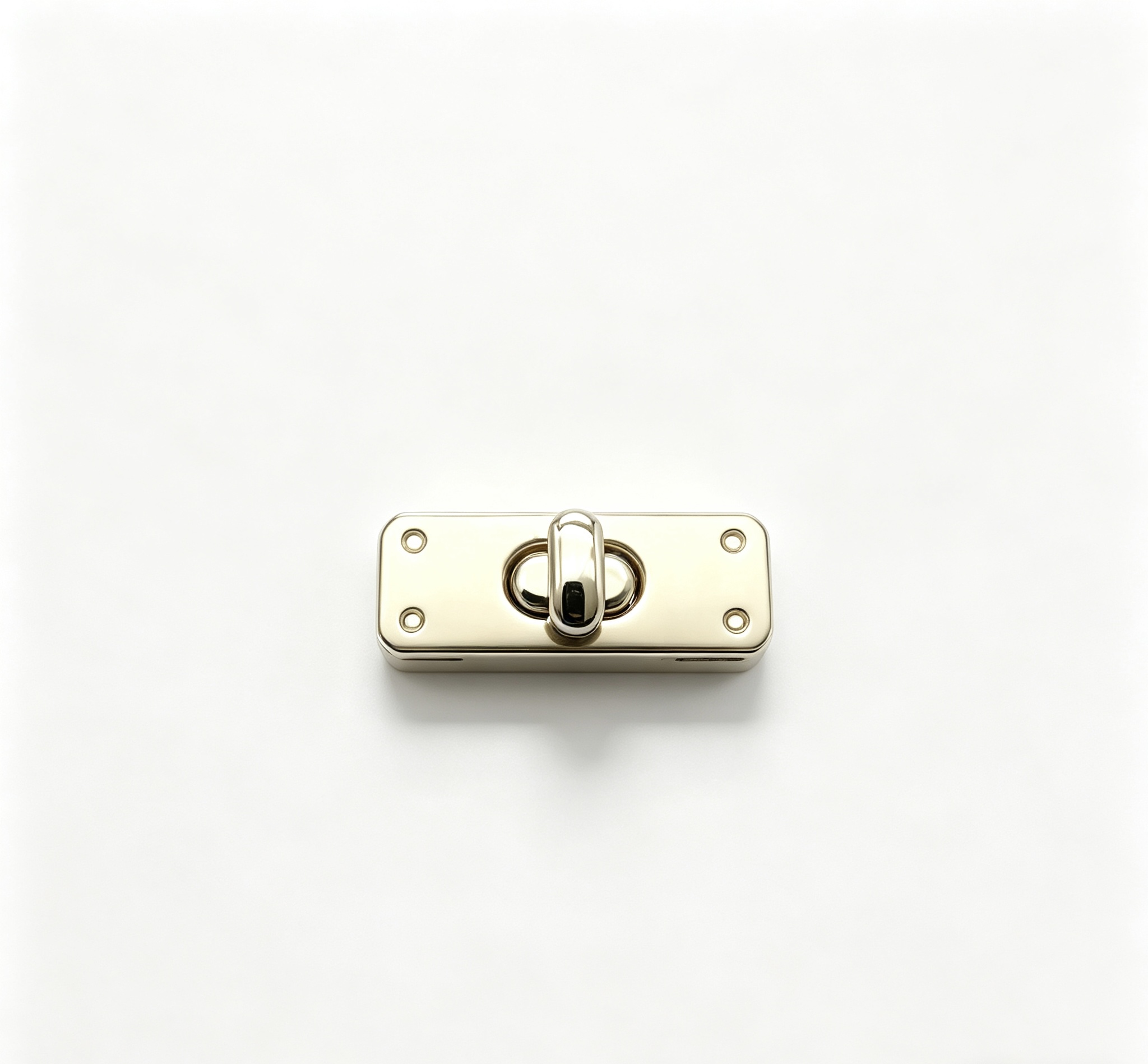 Close-up of a high-polish light gold rectangular twist lock featuring four decorative corner rivets for luxury handbags, custom manufactured by Wahkoi Metal