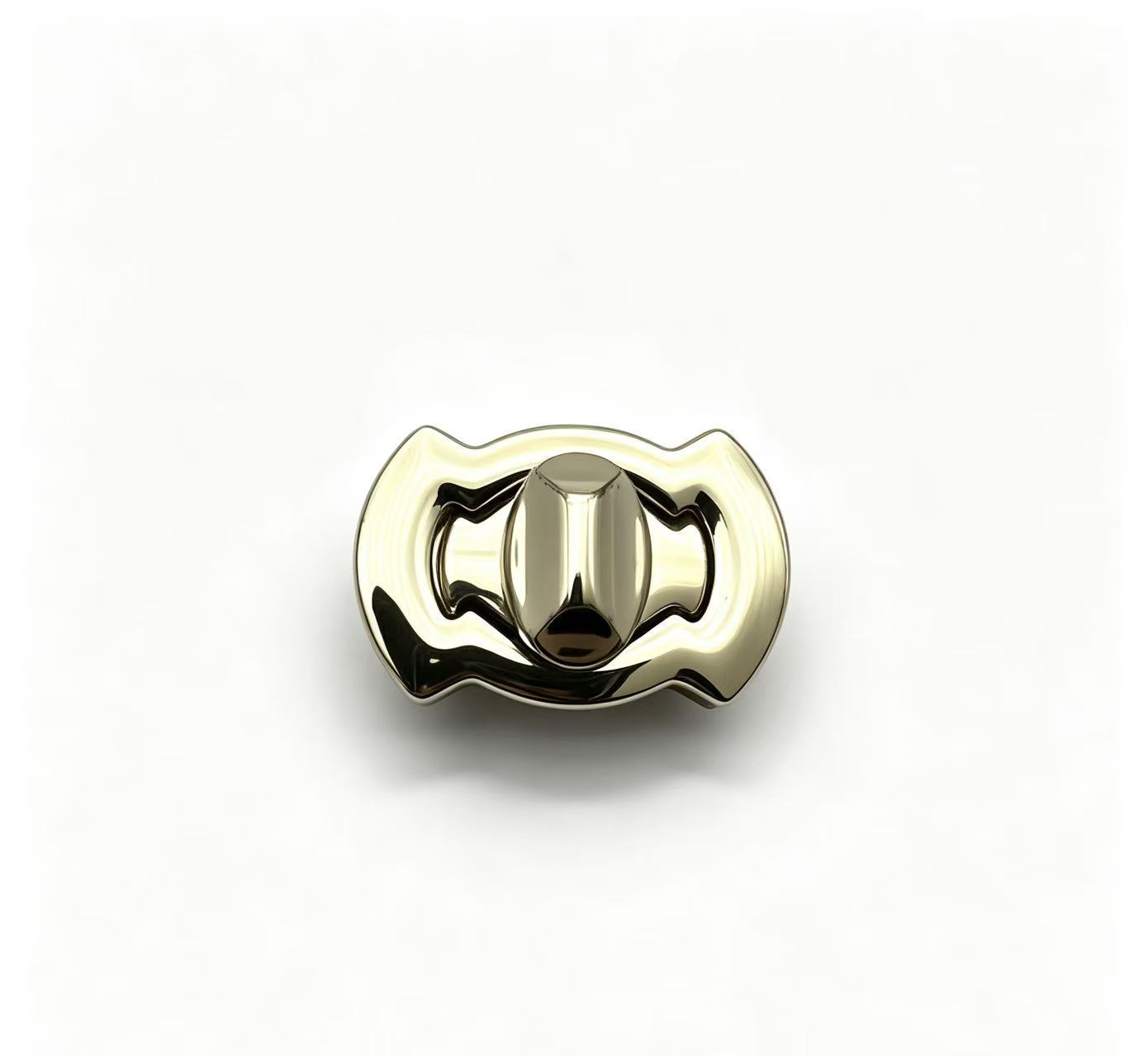 Close-up of a high-polish light gold twist lock featuring a sculptural wavy silhouette for luxury handbags, custom manufactured by Wahkoi Metal