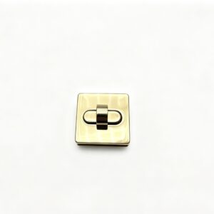 Close-up of a high-polish light gold soft square twist lock featuring a recessed oval center for luxury handbags, custom manufactured by Wahkoi Metal