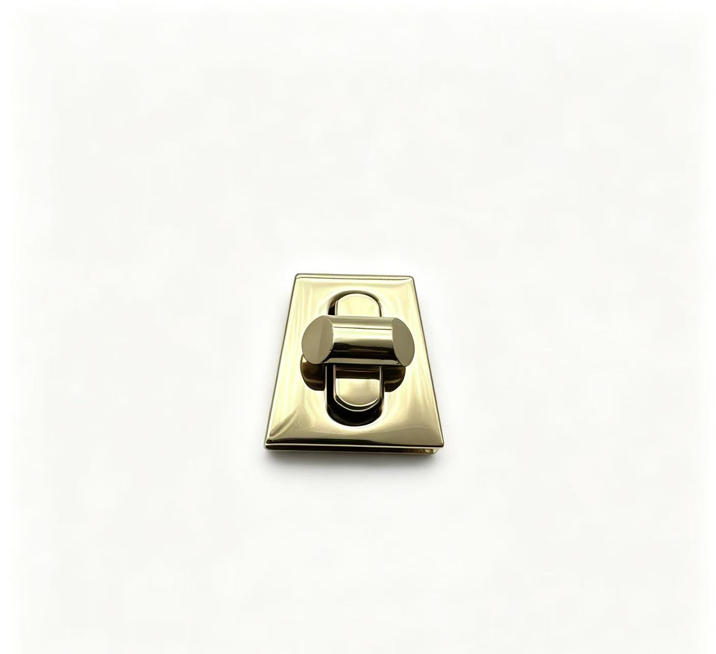 Premium polished gold zinc alloy trapezoid turn lock for luxury handbags, custom manufactured by Wahkoi Metal.